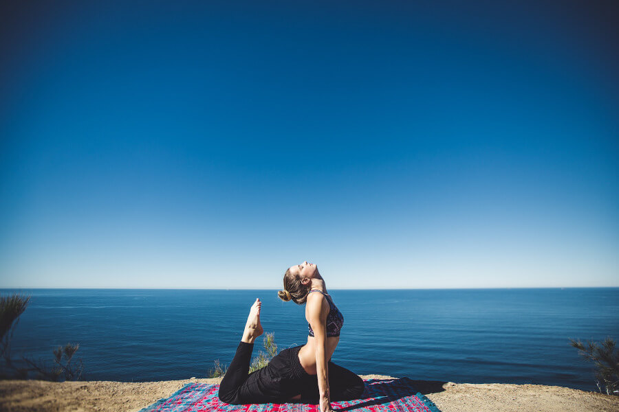 Frau beim Yoga-Retreat am Meer